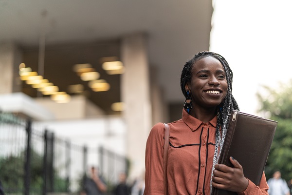 Professional woman holding binder outside office building